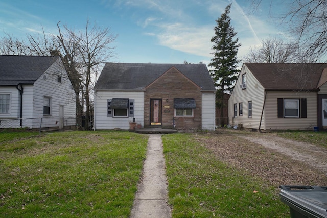 view of front facade featuring a front lawn and fence