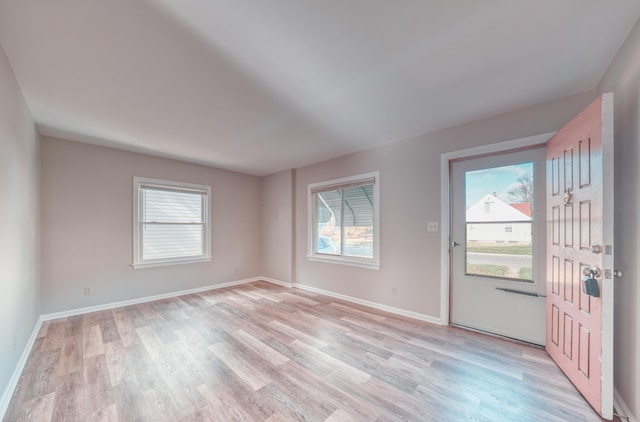 foyer entrance featuring baseboards and light wood finished floors