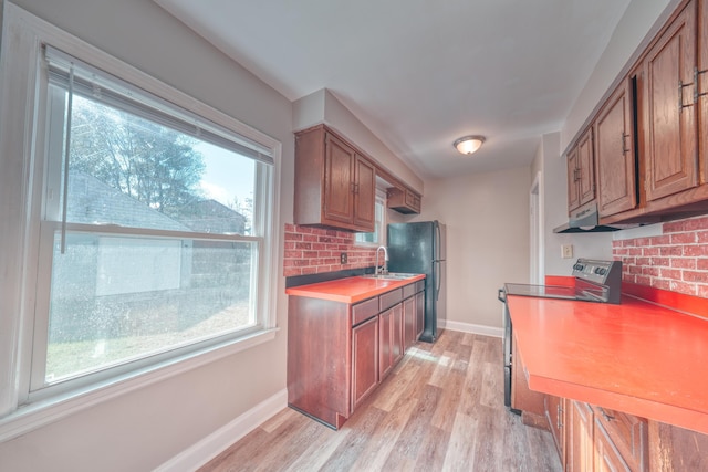 kitchen featuring brown cabinetry, decorative backsplash, stainless steel electric range oven, and a sink