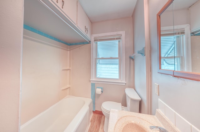 bathroom featuring bathtub / shower combination, vanity, toilet, and wood finished floors