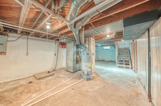 unfinished basement with heating unit, stairway, gas water heater, and electric panel