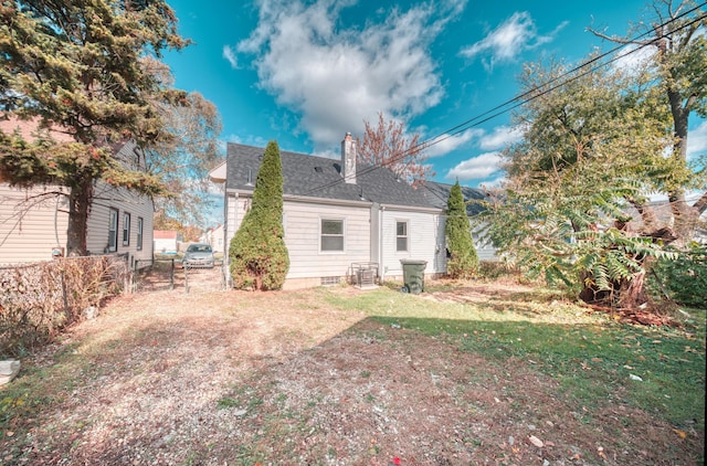 rear view of property with a shingled roof, fence, a chimney, a yard, and a gate