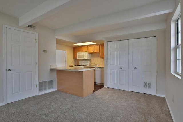 kitchen with beam ceiling, white appliances, light colored carpet, and kitchen peninsula