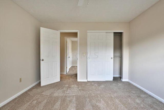 unfurnished bedroom with light colored carpet and a closet