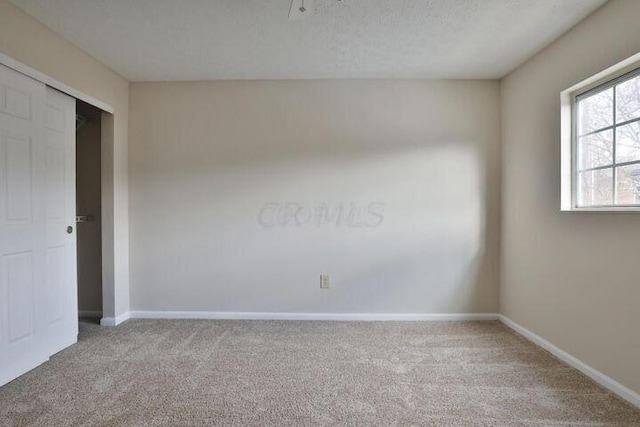 carpeted empty room with a textured ceiling