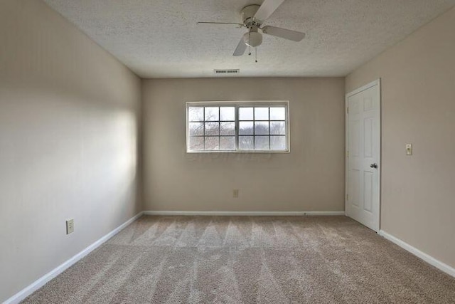 unfurnished room featuring ceiling fan, light carpet, and a textured ceiling