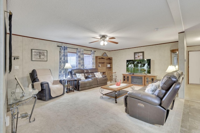 living room featuring crown molding, light carpet, ceiling fan, and a textured ceiling