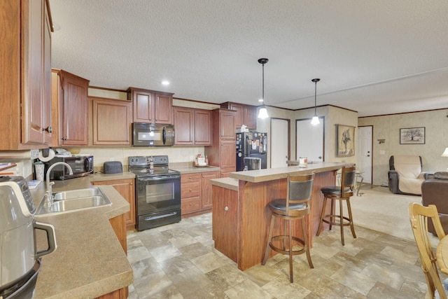 kitchen featuring sink, a breakfast bar area, a kitchen island, pendant lighting, and black appliances