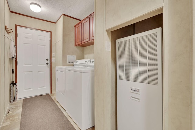 laundry area with cabinets, ornamental molding, washing machine and clothes dryer, and a textured ceiling