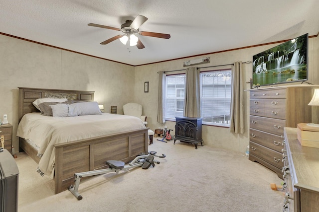 carpeted bedroom with crown molding, a wood stove, a textured ceiling, and ceiling fan