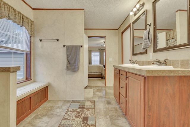 bathroom featuring vanity, ornamental molding, and a textured ceiling