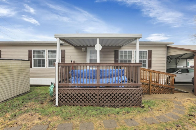 rear view of house featuring a wooden deck and a carport