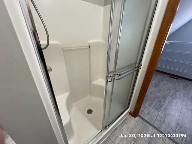 bathroom featuring a shower with door