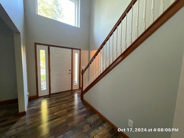 entrance foyer featuring a towering ceiling and dark hardwood / wood-style floors