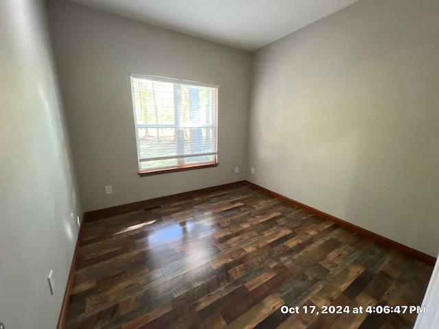 unfurnished room featuring dark wood-type flooring