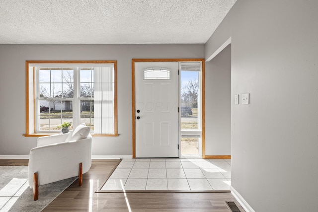 entrance foyer with light wood-type flooring and a textured ceiling