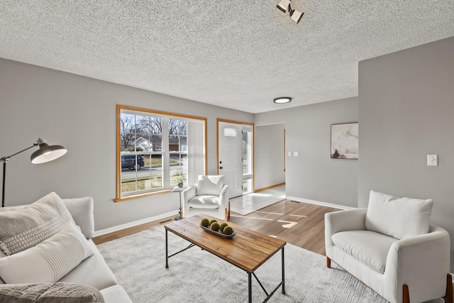 living room with light wood-type flooring and a textured ceiling