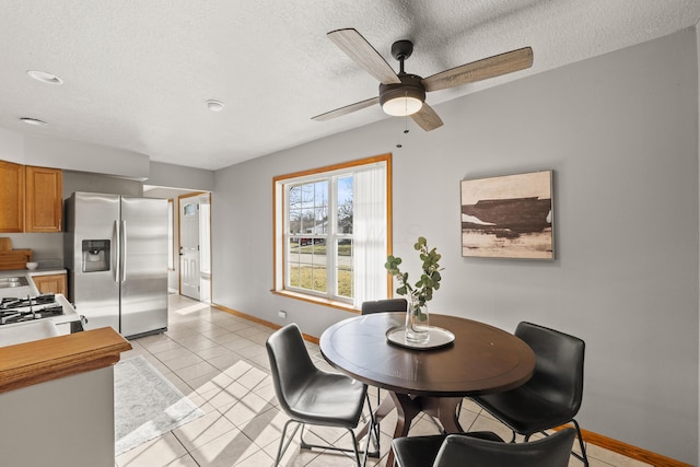 tiled dining space featuring ceiling fan and a textured ceiling