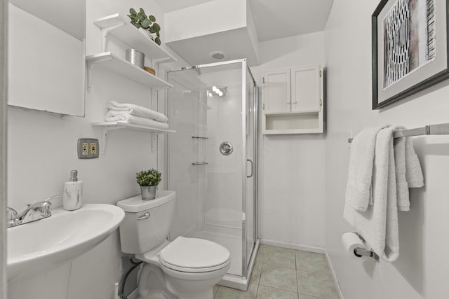 bathroom with sink, tile patterned flooring, a shower with door, and toilet