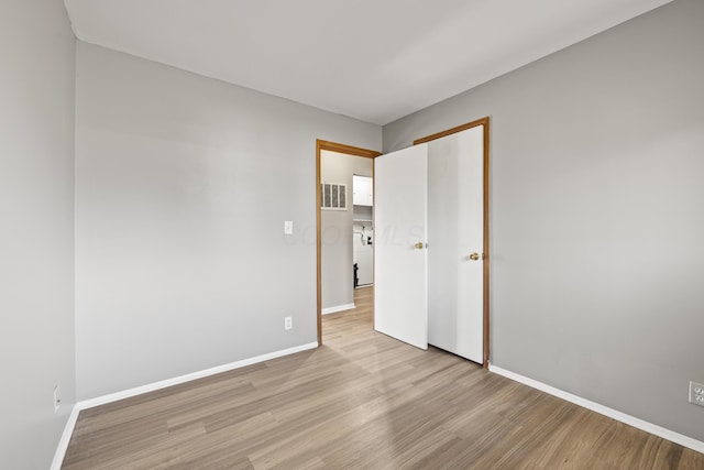 empty room with light hardwood / wood-style flooring