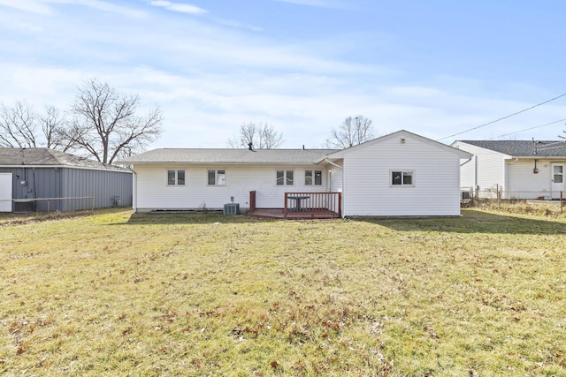 back of house with a deck, cooling unit, and a lawn