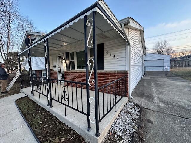 view of front facade with a garage, an outdoor structure, and a porch