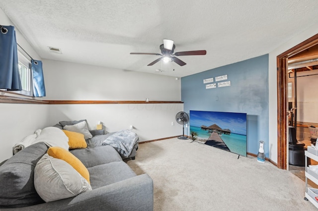 carpeted living room with ceiling fan and a textured ceiling