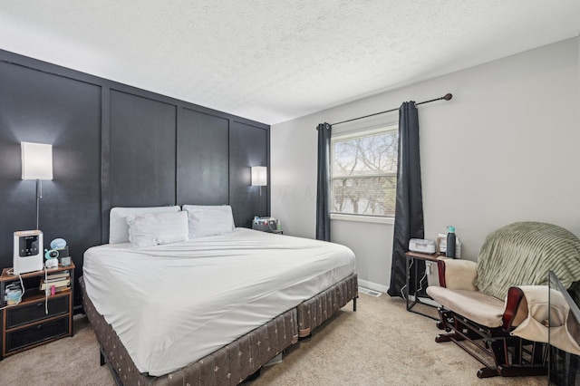 bedroom with light colored carpet and a textured ceiling