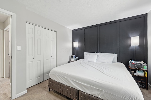 carpeted bedroom with a closet and a textured ceiling