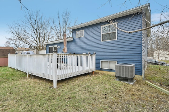 rear view of house with a yard, cooling unit, and a deck