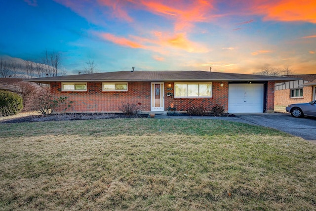 ranch-style home featuring a yard and a garage