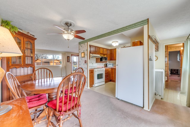 carpeted dining room with ceiling fan and a textured ceiling