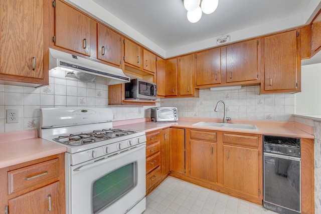 kitchen with sink, backsplash, and white gas range oven