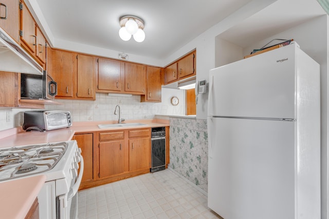 kitchen with sink, white appliances, and decorative backsplash