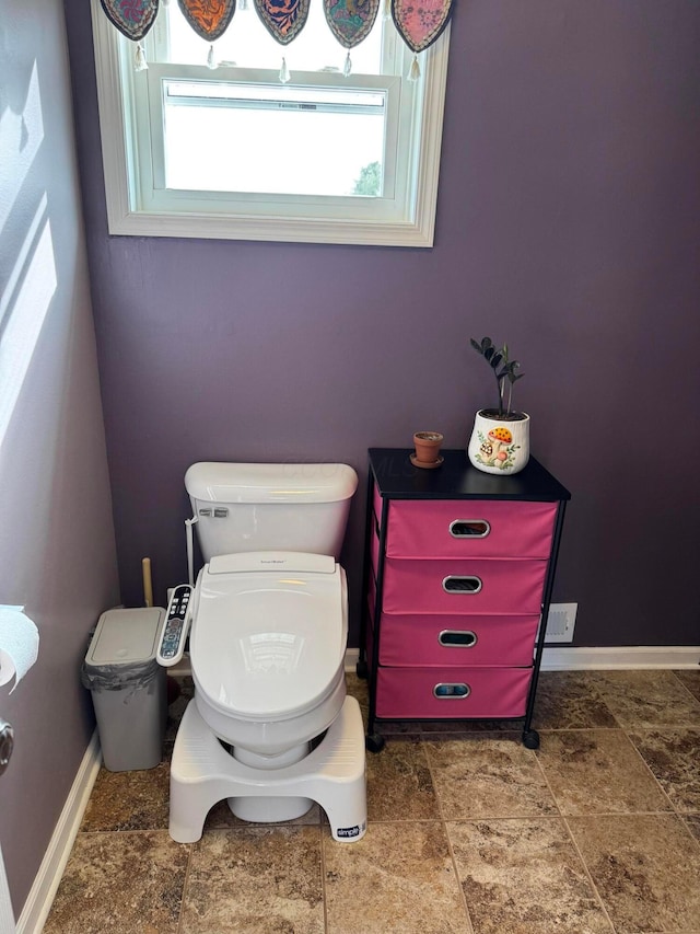 bathroom with toilet and a healthy amount of sunlight