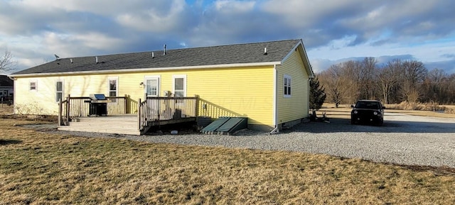 back of house featuring a yard and a deck