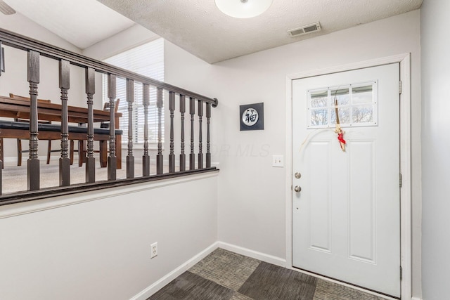 foyer with a wealth of natural light and a textured ceiling