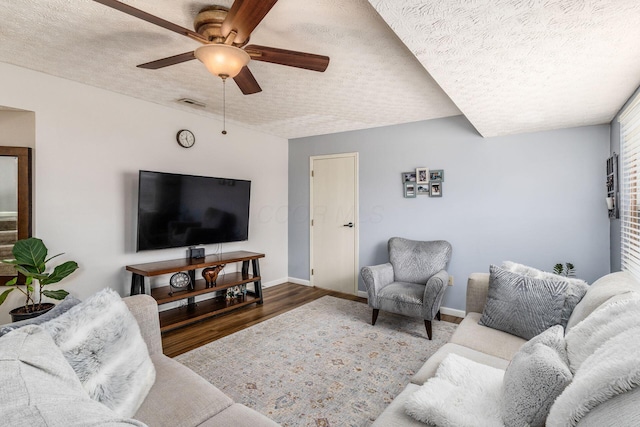 living room with hardwood / wood-style flooring, a textured ceiling, and ceiling fan