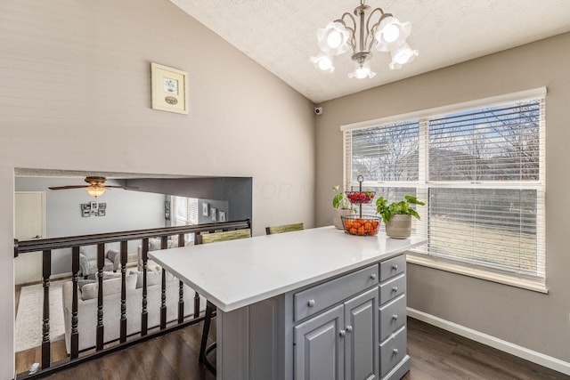 kitchen with dark hardwood / wood-style floors, decorative light fixtures, gray cabinetry, a kitchen bar, and a center island