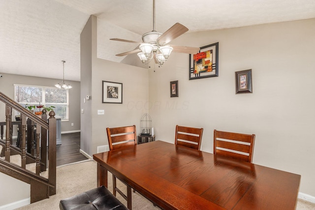 dining room featuring ceiling fan with notable chandelier, a textured ceiling, and carpet