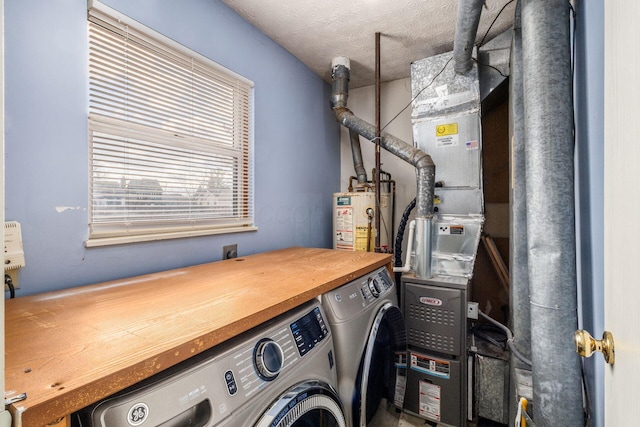 laundry area featuring water heater, a textured ceiling, and independent washer and dryer