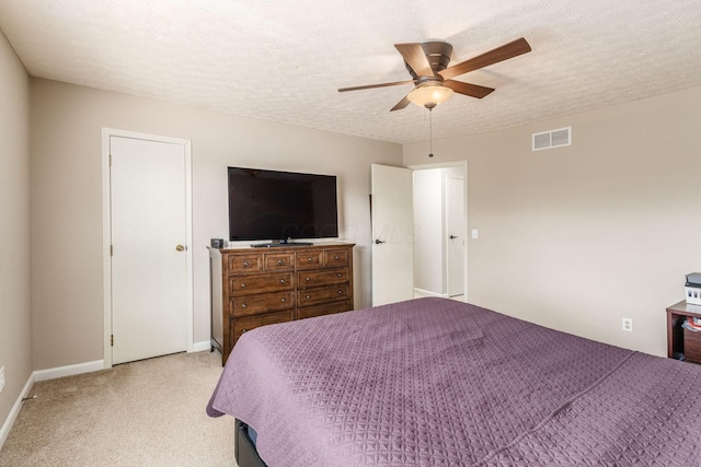 bedroom featuring ceiling fan, sink, light carpet, and a textured ceiling