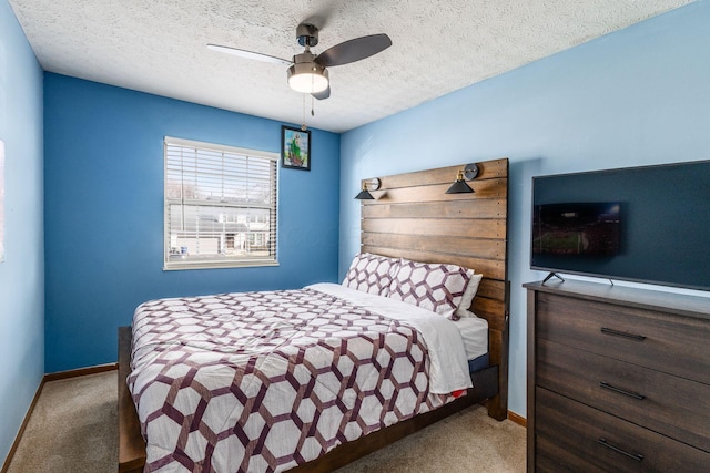 carpeted bedroom featuring ceiling fan and a textured ceiling