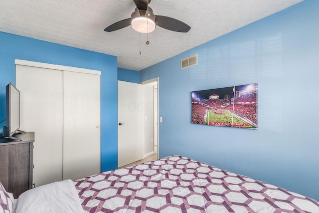 bedroom with ceiling fan, a closet, and a textured ceiling