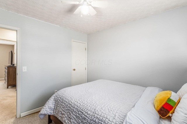 bedroom with light carpet, ceiling fan, and a textured ceiling