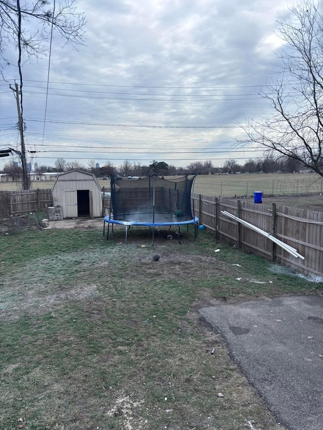 view of yard with a trampoline and a storage shed