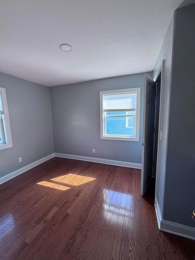 empty room featuring baseboards and wood finished floors