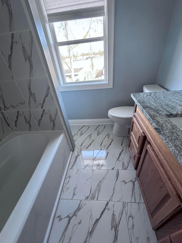 full bathroom with toilet, marble finish floor, a washtub, baseboards, and vanity