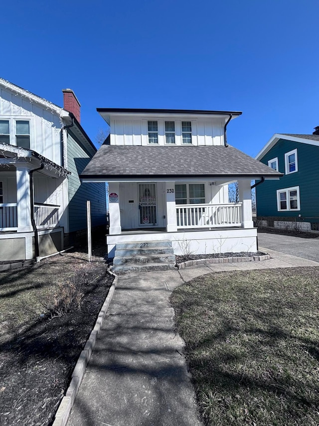 view of front of house with covered porch, board and batten siding, and a shingled roof