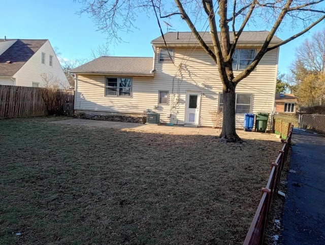 back of house with a patio and a lawn